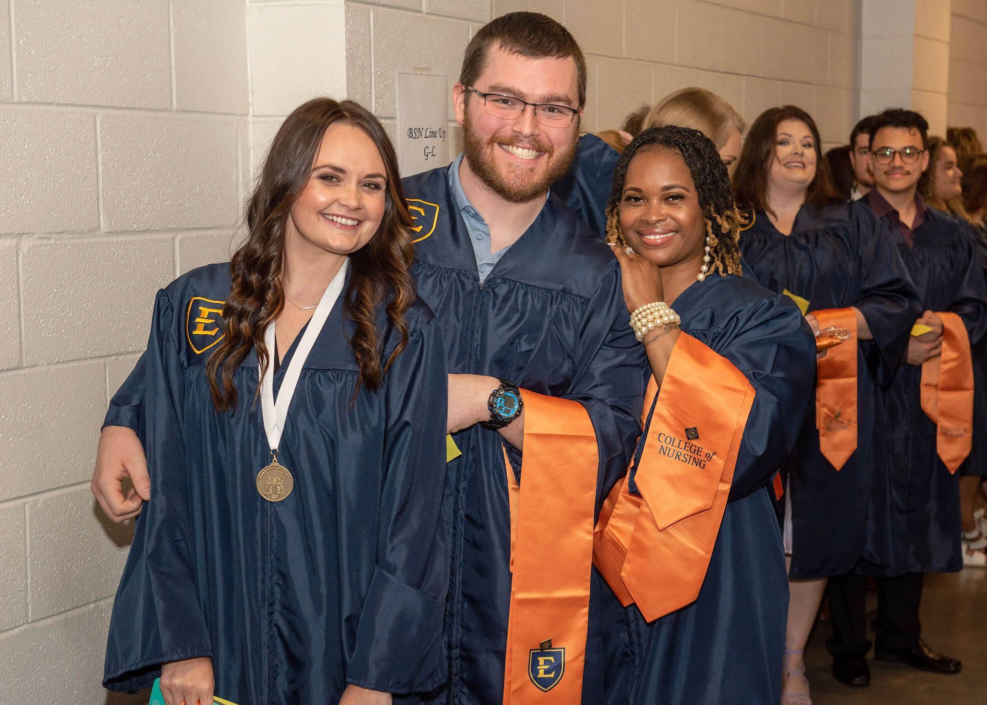 ETSU nursing students in graduation robes smiling for the camera.