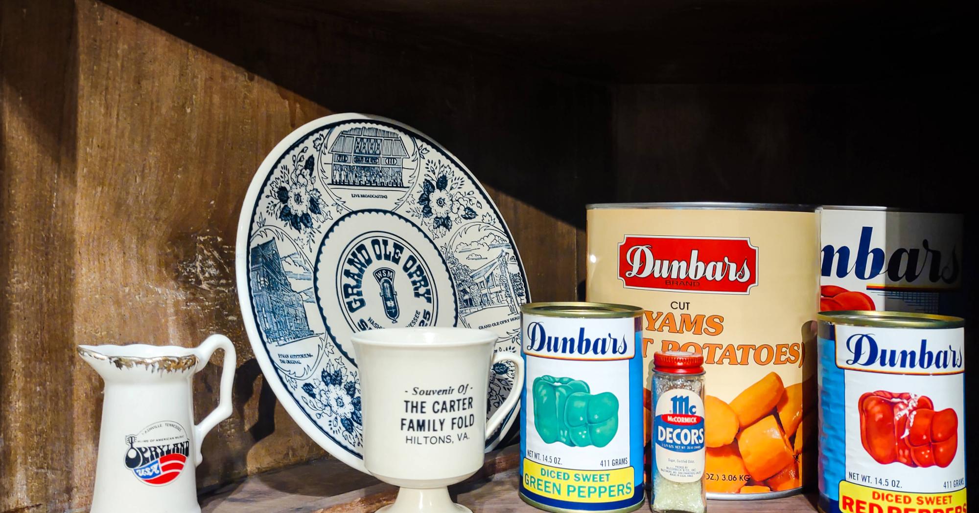 Image artifacts inside a cabinet, including canned yams, canned diced sweet red peppers, and a Grand Ole Opry plate.