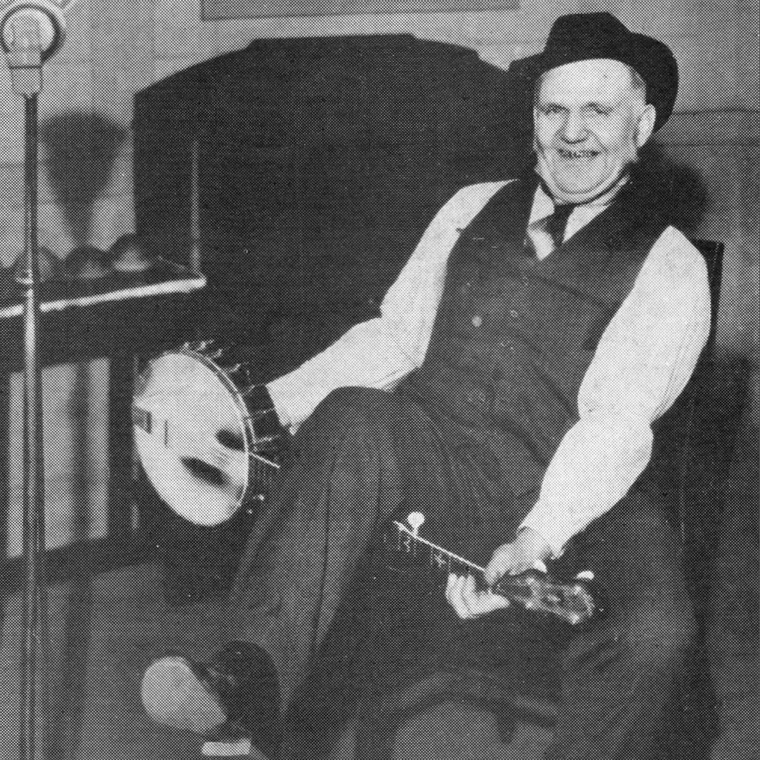 Uncle Dave Macon with a banjo under his leg