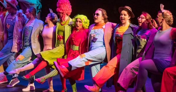 Performers linking arms and dancing in a recent ETSU theatre performance