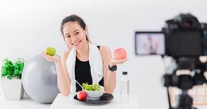 Student holding apple while filming video