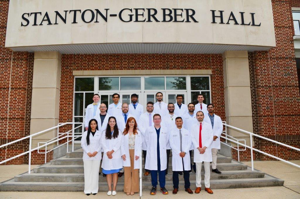 group photo of doctors in white coats standing on steps