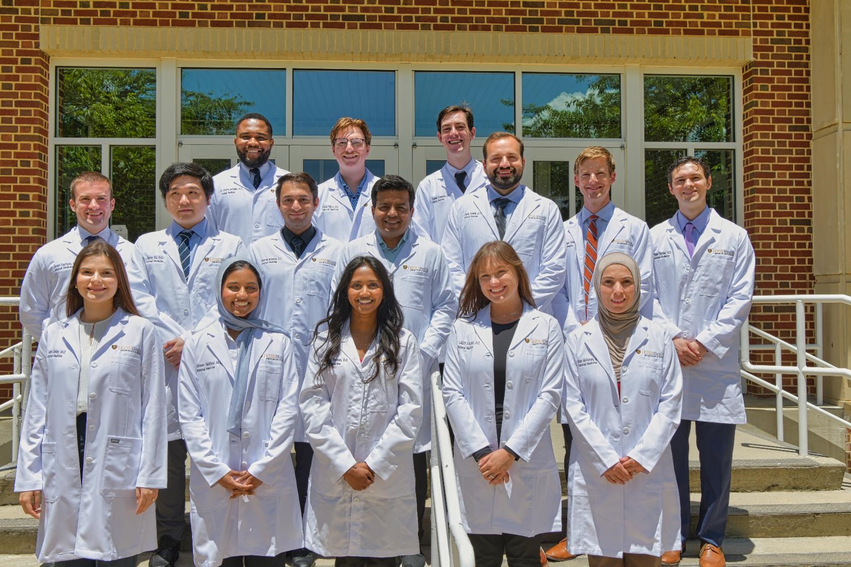 group photo of doctors in white coats standing on steps
