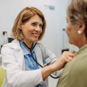 Physician listening to senior patient's heartbeat.