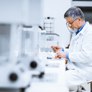 Senior male researcher carrying out scientific research in a lab.