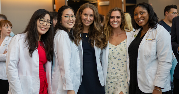 Students pose for a photo together after the white coat ceremony