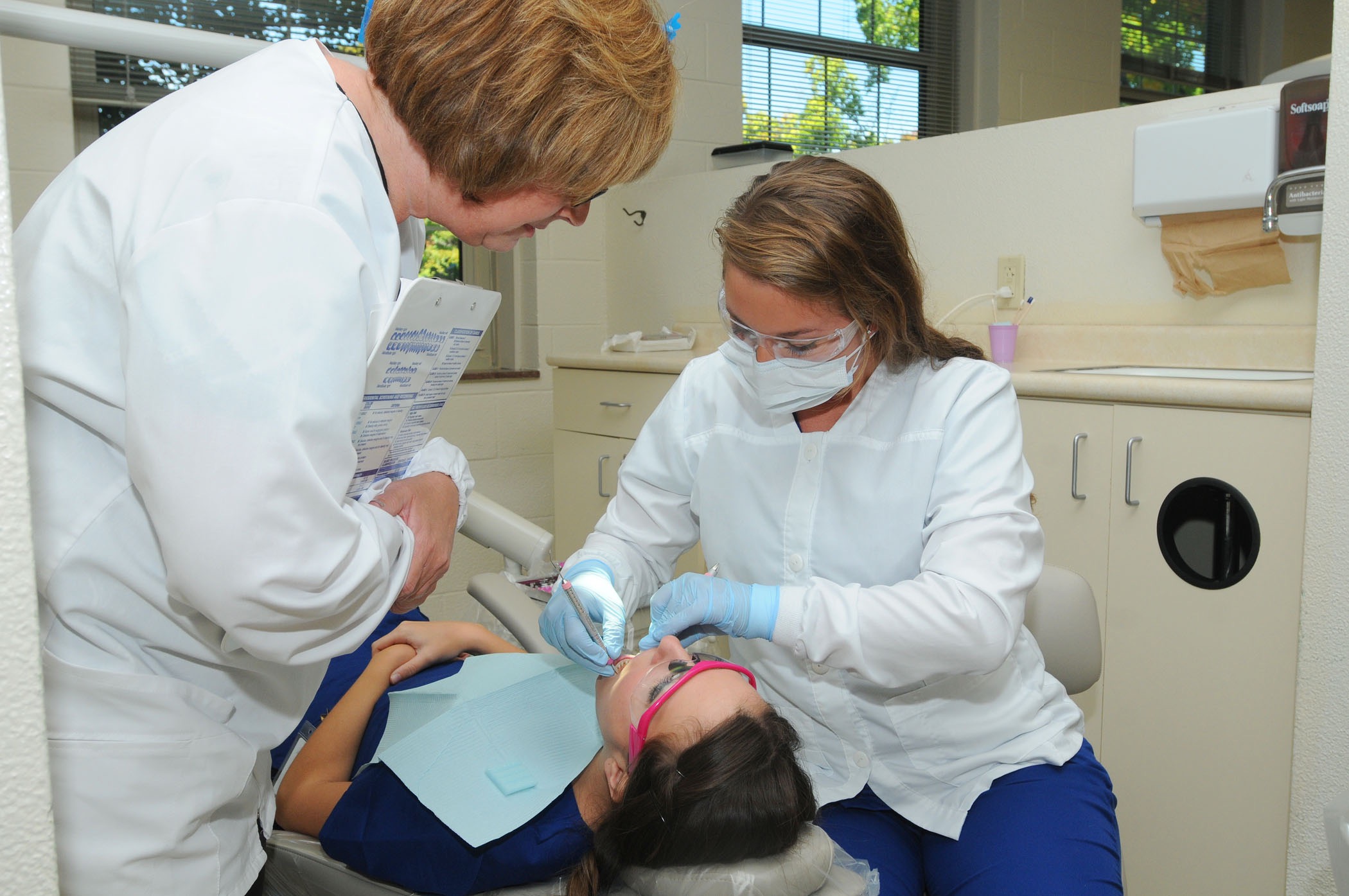 students with a patient in the dental hygiene clinic