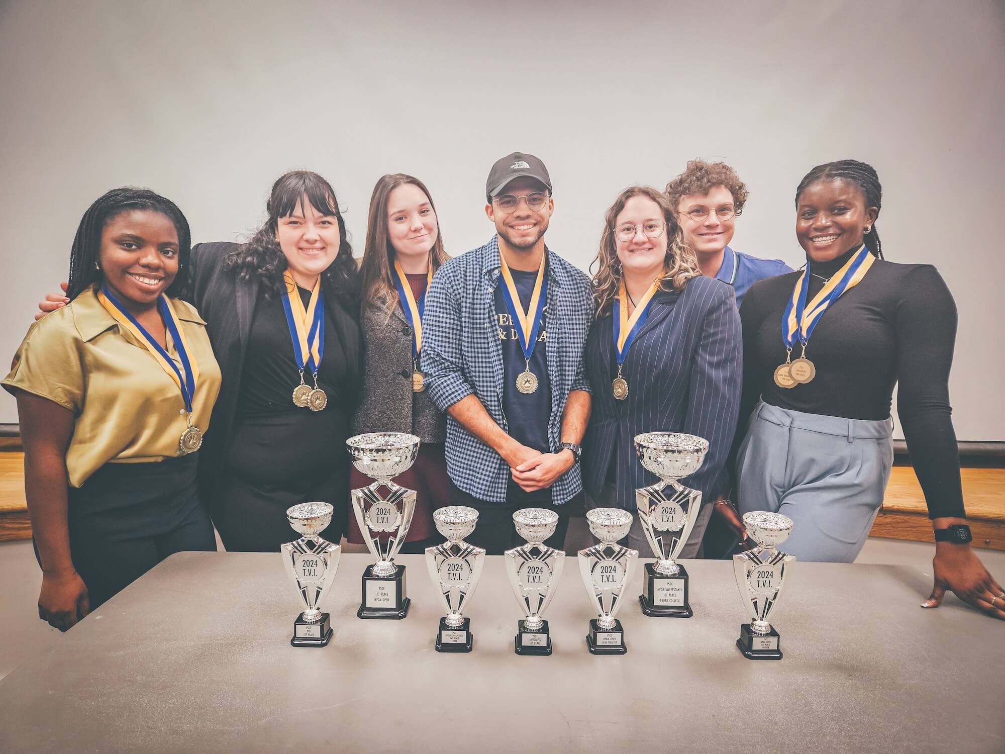 Group photo of ETSU’s Speech and Debate Team with numerous medals and trophies.