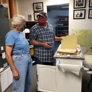 Student and professor examine archives.