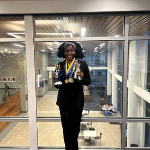 Ijeoma holding several trophies