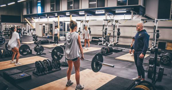 An ETSU student in a weighlifting class being coached by an instructor