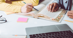 people working on a reading in front of a laptop